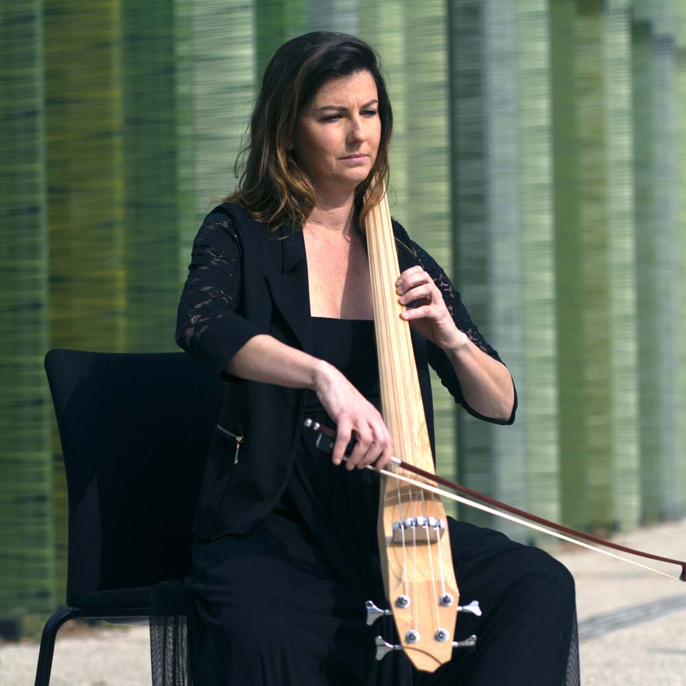 a Horizon electric cello played by a cellist in a seated position